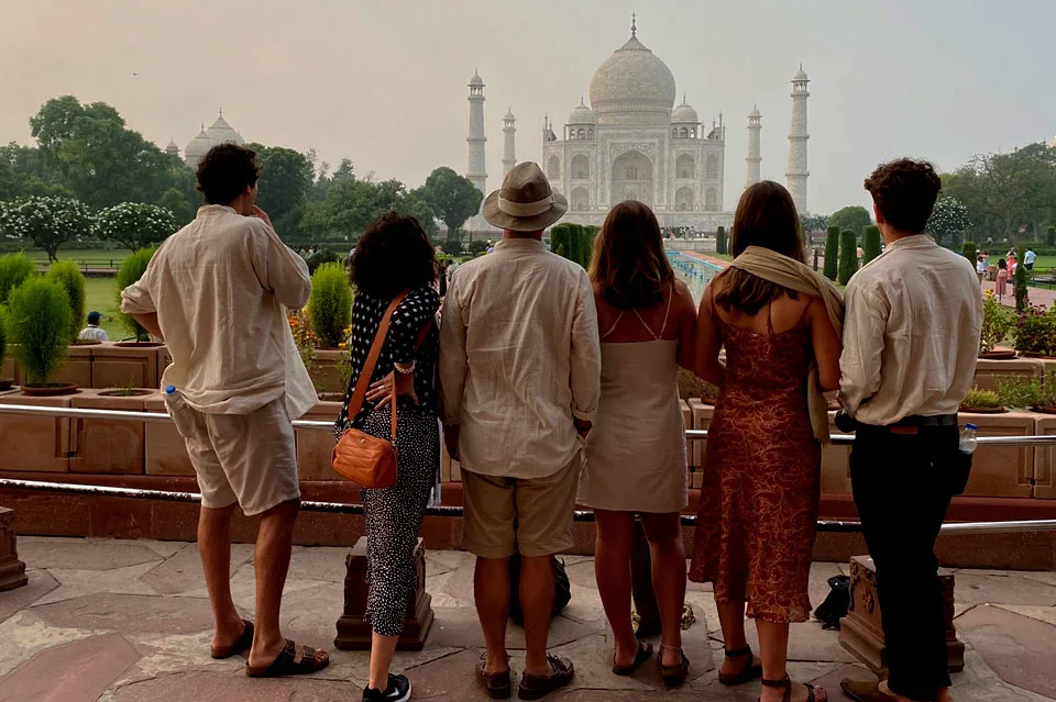 Group of tourists standing and admiring the Taj Mahal in Agra, India during the day